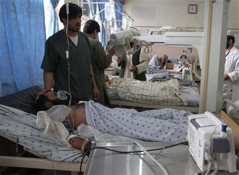 Afghan victims of a suicide attack are seen on beds at the hospital in Kandahar, south of Kabul, Afghanistan, Tuesday, Jan. 3. A suicide bomber driving a motorcycle killed four civilians and a police officer in southern Afghanistan's Kandahar city on Tuesday, police said. 